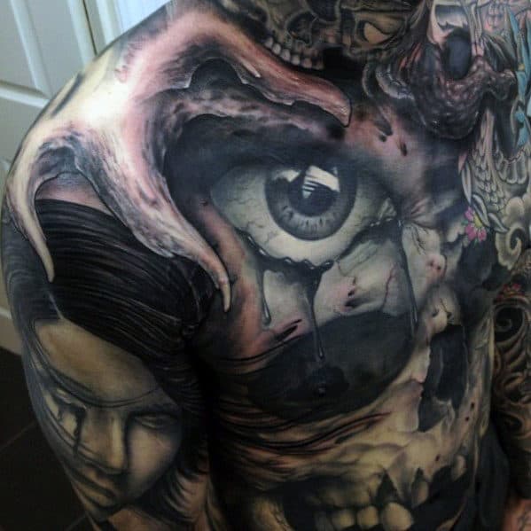 Detailed tattoo featuring a large eye, skull, and various artistic elements