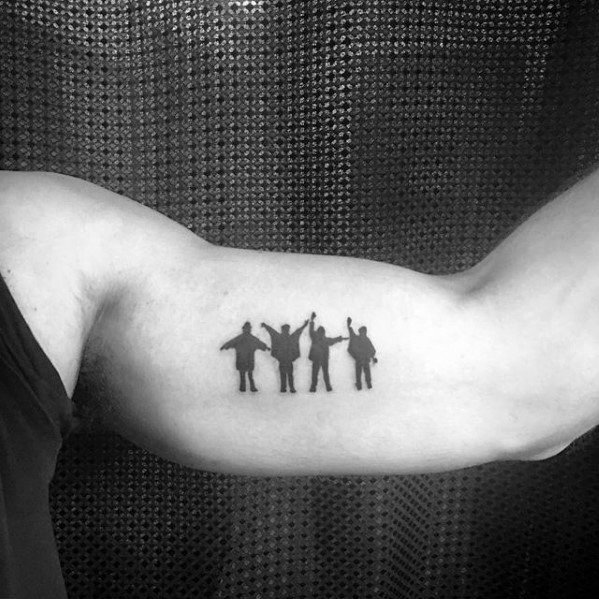 Minimal black silhouette tattoo of The Beatles with arms raised in the iconic "Help!" pose, placed on the inner bicep.
