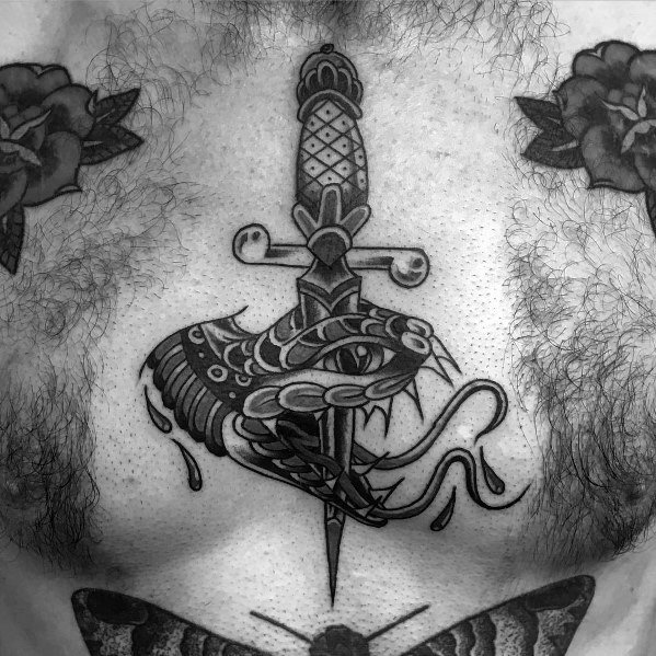 Black and grey snake and dagger tattoo on the chest, featuring bold shading, intricate details, and a fierce traditional design.