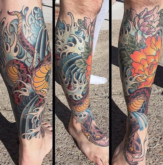 A vibrant Japanese leg sleeve tattoo featuring a dynamic snake entwined among crashing ocean waves, detailed with orange and yellow hues, floral accents, and traditional Japanese elements for a striking visual flow