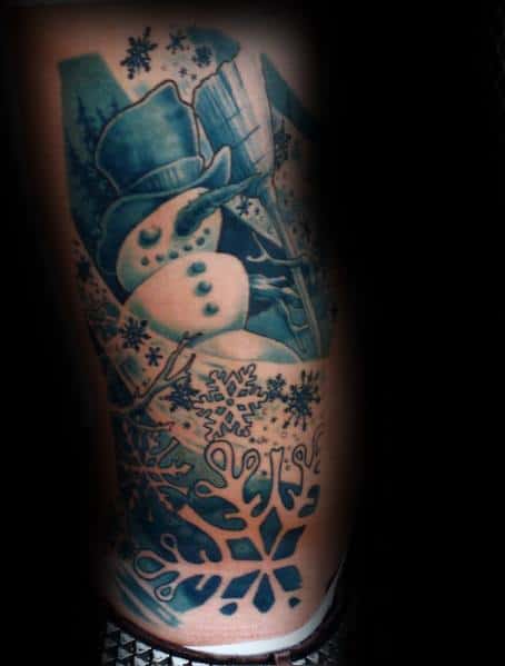 Intricate snowman tattoo in a cool blue tone, featuring a top hat, broom, and detailed snowflakes, creating a frosty and artistic winter scene.