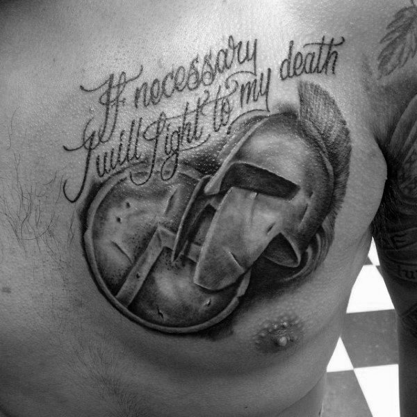 Chest tattoo of a Spartan helmet and shield in black and grey, with cursive script reading “If necessary I will fight to my death.”