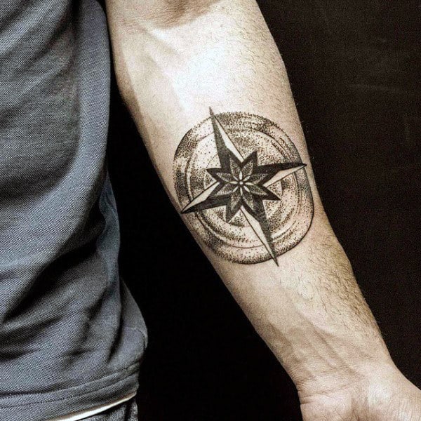 Forearm tattoo of a geometric compass star with shading and detailed patterns