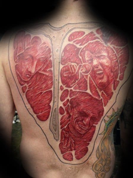 Tattoo of a large T-bone steak covering the entire back, with highly detailed faces sculpted into the meat, creating a surreal and bold design
