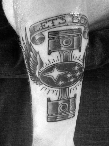 Black and grey Subaru-themed tattoo featuring pistons, wings, the Subaru logo, and a "LET'S BOX" banner, symbolizing the iconic boxer engine.