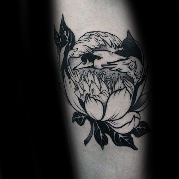 Blackwork tattoo of a swan nestled within a blooming flower, combining nature and elegance in a clean, bold illustrative style.