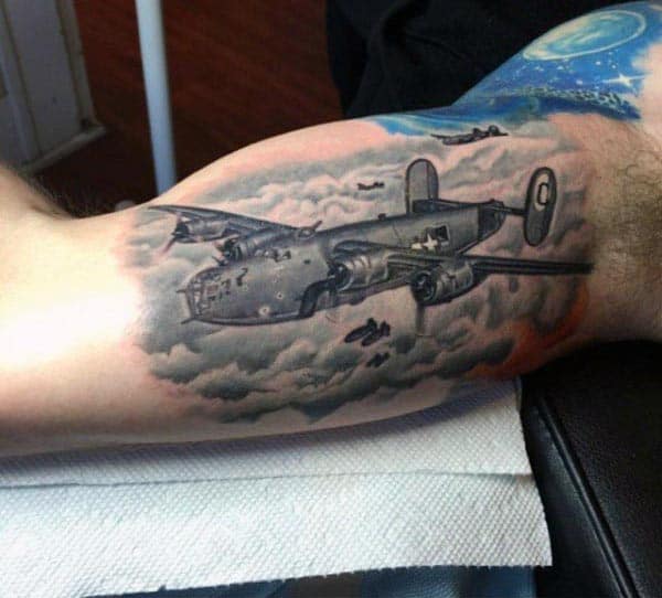 Realistic tattoo of a World War II bomber flying through clouds, with detailed shading and a vibrant sky background on the inner bicep
