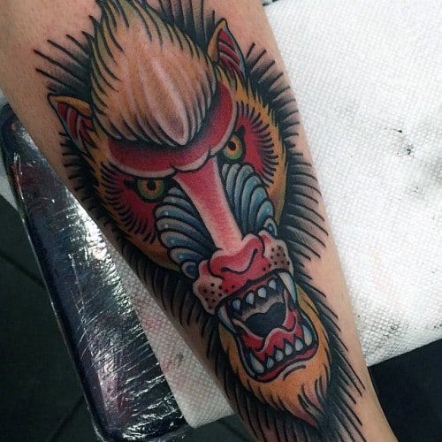Neo-traditional baboon tattoo with bold outlines, vivid colors, and an intense expression, creating a dynamic and striking forearm design.