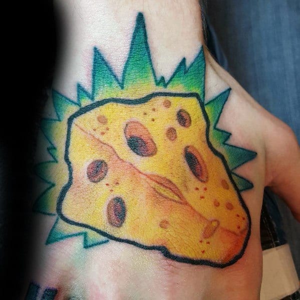 Colorful tattoo of a wedge of Swiss cheese with bold black outlines, yellow shading, and a vibrant green explosion-like background on the foot.