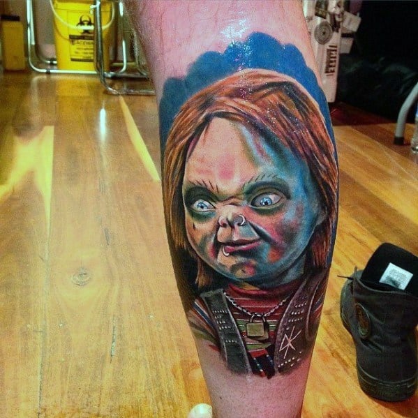 Realistic Chucky tattoo with vivid colors, featuring his eerie expression, glowing blue eyes, and intense shading for a bold horror-inspired design.