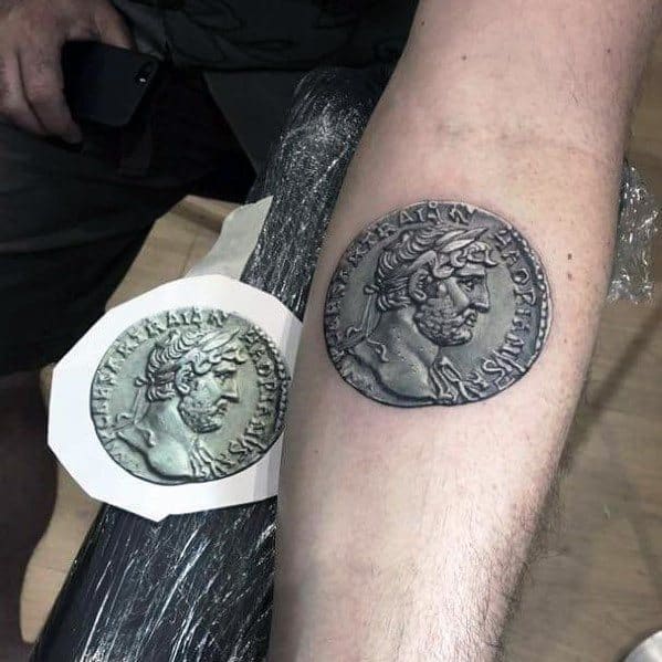 Realistic tattoo of an ancient Roman coin featuring Emperor Hadrian, with intricate shading for a detailed and three-dimensional effect.