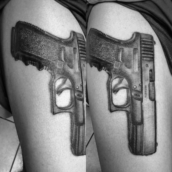 Realistic black and grey tattoo of a Glock pistol on the thigh, featuring detailed shading and depth for a bold and three-dimensional effect.