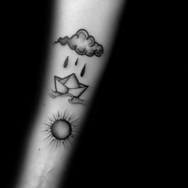 Paper boat tattoo with rain cloud and sun, symbolizing life's ups and downs, resilience, and hope through challenges.