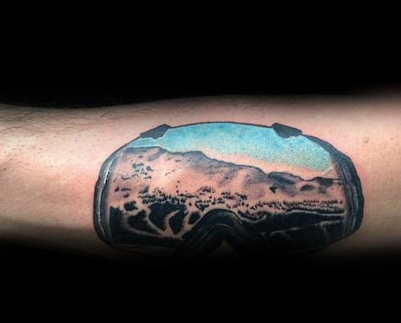 Tattoo of ski goggles reflecting a snowy mountain landscape, capturing the thrill of winter sports with a detailed and realistic design.