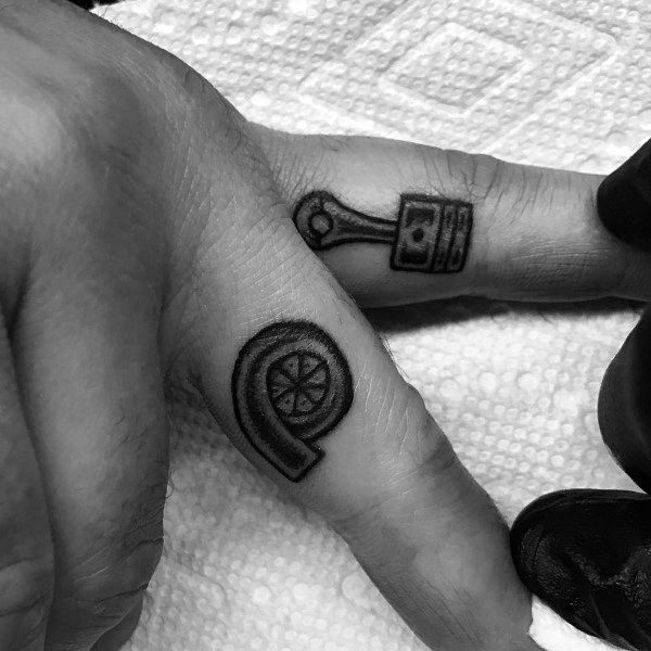 Minimalist turbocharger and piston tattoos on the fingers with bold black outlines, symbolizing a passion for speed, mechanics, and automotive culture.