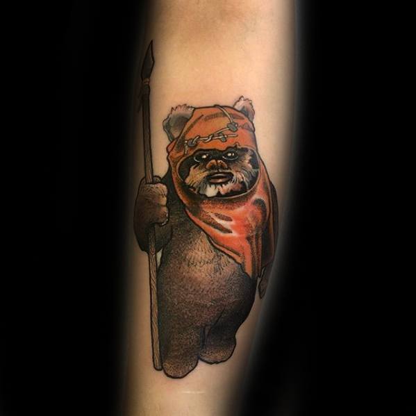 Clean and detailed Ewok tattoo with an orange hood and spear, standing upright with a calm expression on a softly shaded background.