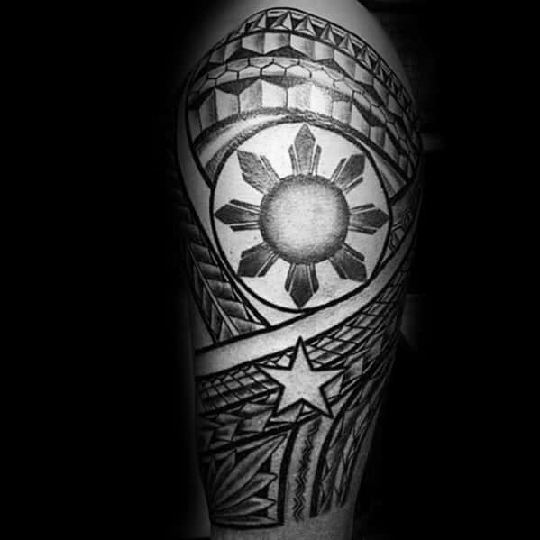 Filipino sun tattoo with detailed shading, eight rays, a bold star below, and intricate tribal patterns wrapping around the upper arm.