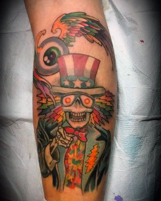 Grateful Dead Uncle Sam skeleton tattoo with glowing eyes, rainbow hair bursts, and psychedelic suit, pointing forward with bold detail.