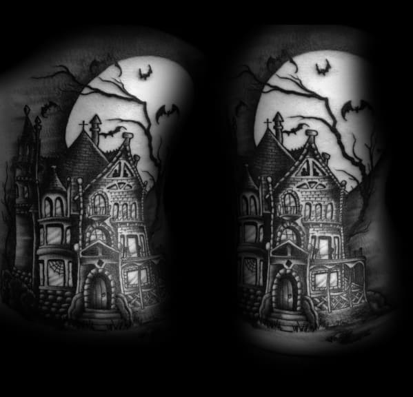 Black and grey haunted house tattoo with glowing windows, twisted trees, flying bats, and a giant full moon casting an eerie glow.