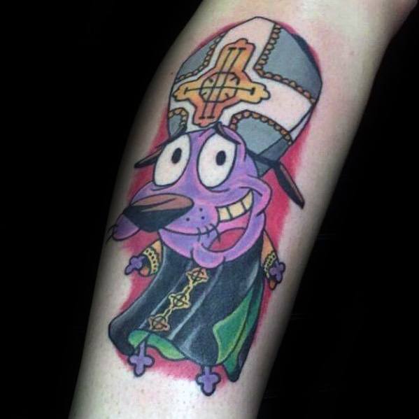 Tattoo of Courage the Cowardly Dog dressed as a pope, wearing a detailed robe and tall mitre hat, with a red glow in the background.