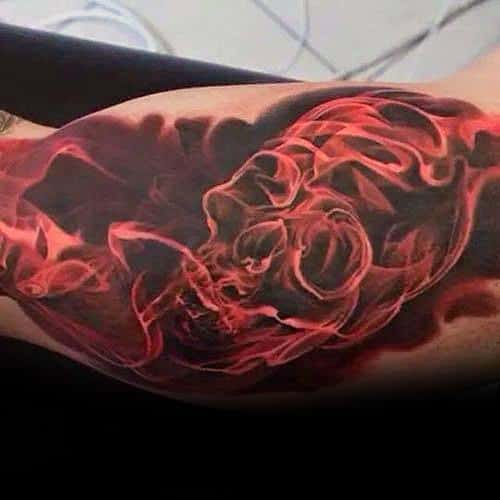 Tattoo of a red burning skull design on a biceps