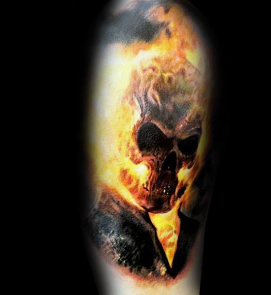 Ghost Rider tattoo with a dark, realistic flaming skull, glowing eyes, and intense fire engulfing the head and shoulders in vivid detail.