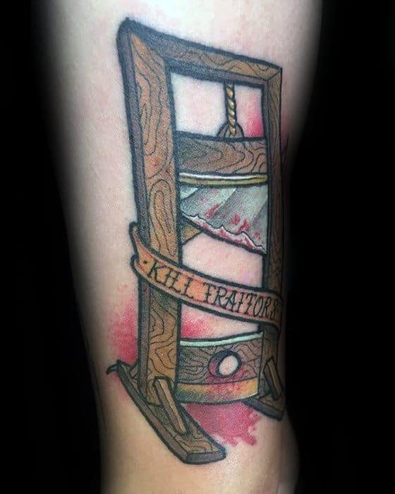 Color guillotine tattoo with woodgrain texture, a blood-stained blade, red splatter background, and a banner reading “KILL TRAITORS.”