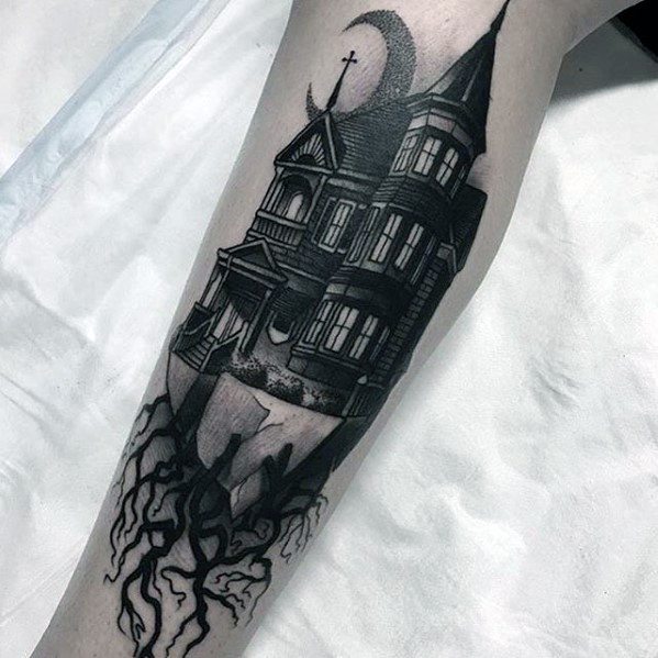 Forearm tattoo of a gothic haunted house on a floating cliff with exposed roots, crescent moon above, and dark shading for a spooky effect.