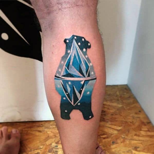 Colorful tattoo of a bear silhouette filled with a geometric iceberg and night sky, blending nature and abstract design.