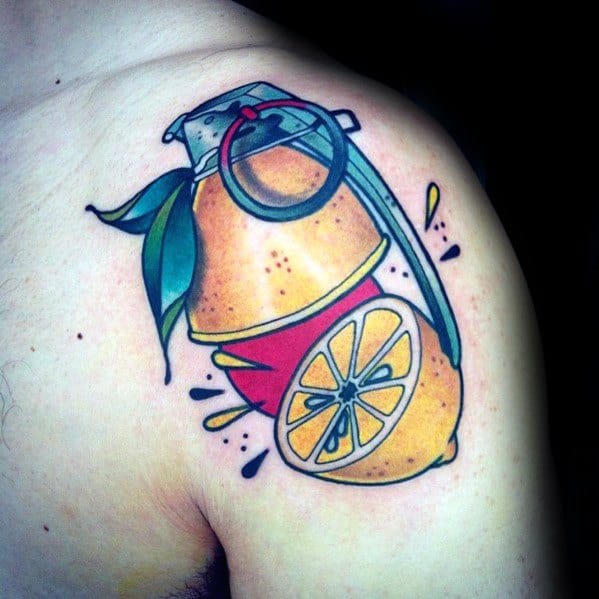 Colorful tattoo of a lemon transformed into a grenade with a pin, leaves, and juice splashes, blending fruit and explosive imagery.