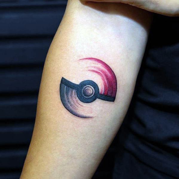 Minimalist Pokeball tattoo with dynamic red and black swirl effect, creating a motion-inspired look on the inner forearm.