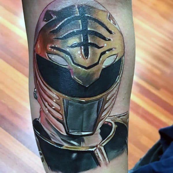 Hyper-realistic White Ranger helmet tattoo with golden highlights, reflective visor, and fine detailing on the upper arm.