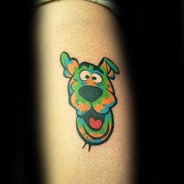 Colorful psychedelic-style tattoo of Scooby-Doo’s face with exaggerated features and a playful expression.