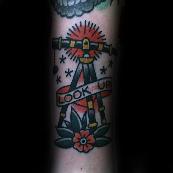 Tattoo of a telescope, stars, and flower with "Look Up" banner