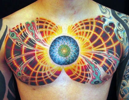 Vivid chest tattoo with a central mandala radiating fiery energy patterns and symmetrical grid-like designs across both sides.
