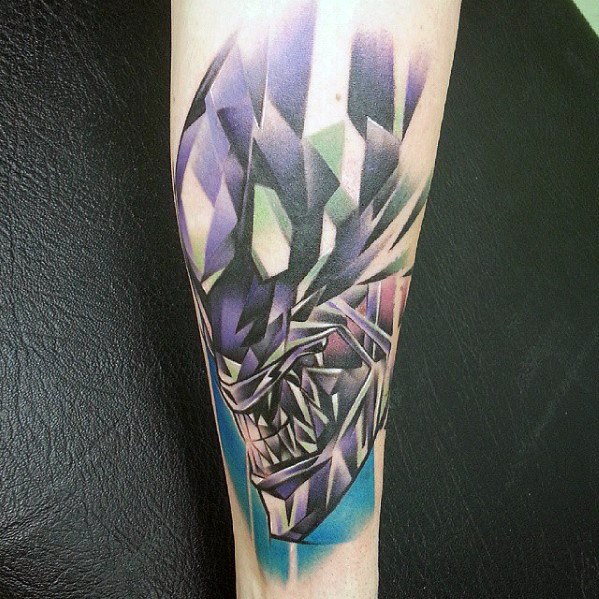 Geometric Xenomorph tattoo with abstract polygonal shapes in purple, green, and blue, creating a modern, angular alien design.