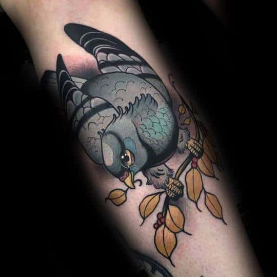 Neo-traditional pigeon tattoo with muted tones, perched among golden leaves and acorns, blending elegance with classic tattoo flair.