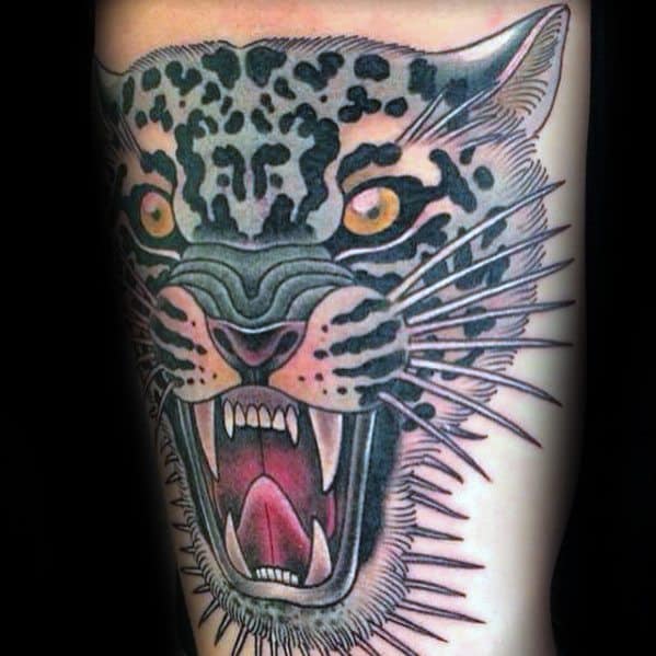 Traditional snow leopard tattoo with exaggerated whiskers, wide-open mouth, and intense yellow eyes for a bold and fierce look.