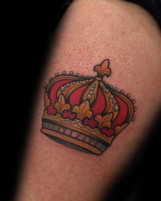 Bold traditional tattoo of a royal crown in red, gold, and black with pearl-like accents and thick outlines.