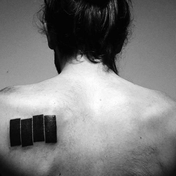 Black Flag bars tattooed on the upper back near the shoulder blade, angled slightly to echo the raw energy of punk defiance.