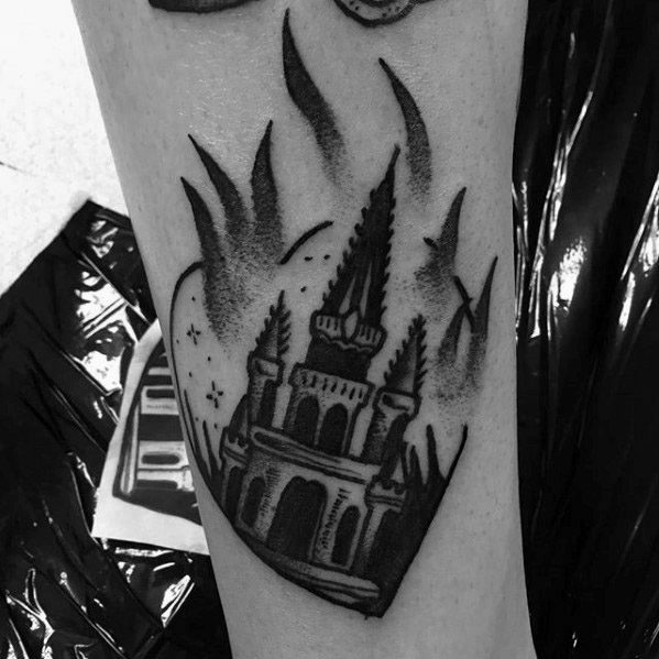 Blackwork tattoo of a gothic-style burning castle or church inside a heart shape. Flames and stars surround the structure for a bold, dramatic effect.