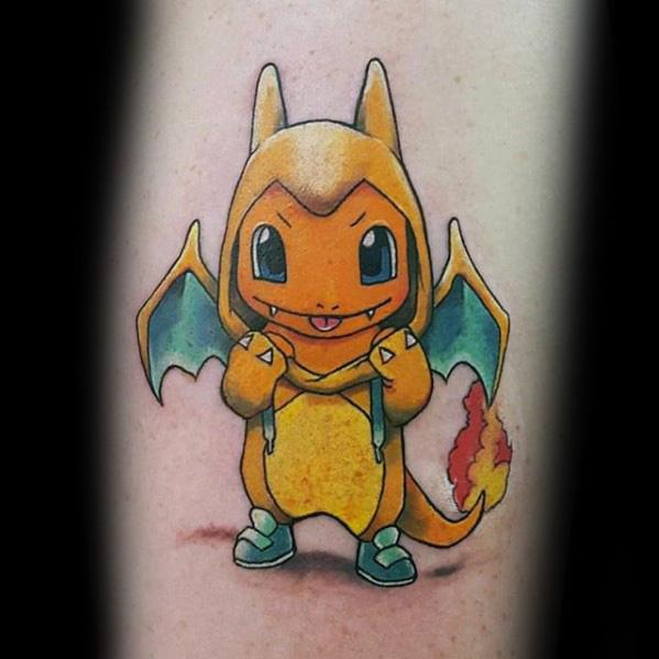 Cute tattoo of Charmander wearing a Charizard hoodie, standing proudly with a mischievous smile and detailed wings on the back.
