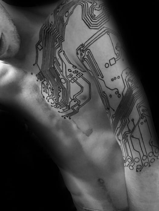 Large black line tattoo of a circuit board design extending from the chest to the arm, resembling electronic pathways across the skin.