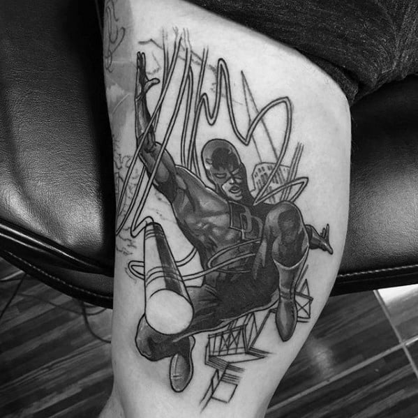 Black and grey Daredevil tattoo in dynamic mid-air pose with bold linework, cityscape details, and swirling baton motion.