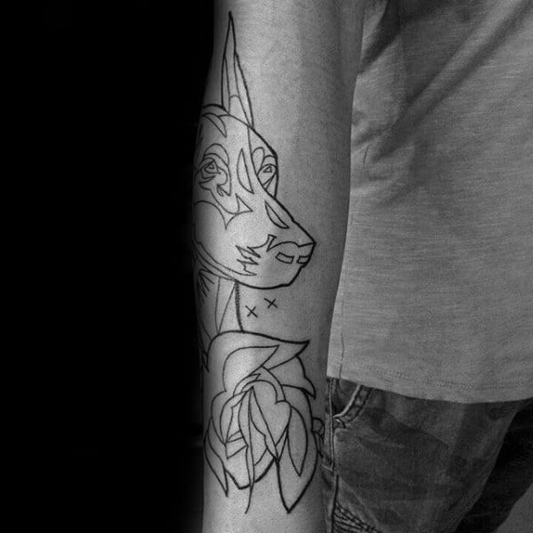 Minimalist Doberman tattoo in fine line style, featuring simple outlines of the dog's face with a large flower and abstract details.