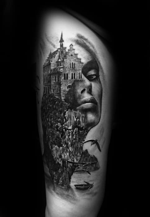 Black and grey tattoo of a woman's face seamlessly blended with a gothic castle on a cliff, surrounded by birds in flight and rocky textures.