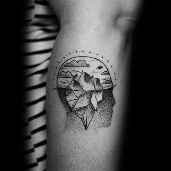 Creative iceberg tattoo inside a human head silhouette, with a starry sky, clouds, and geometric shading symbolizing depth and introspection.