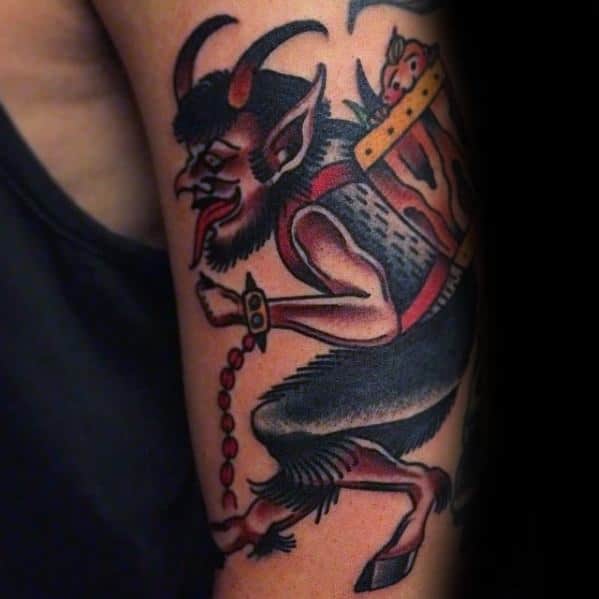 Traditional Krampus tattoo showing the horned creature in motion with chains in hand, carrying a frightened child in a basket on his back.