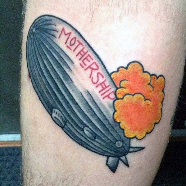 Cartoon-style tattoo of a Zeppelin airship with flames at the back and the word MOTHERSHIP in red, inspired by Led Zeppelin’s compilation album.