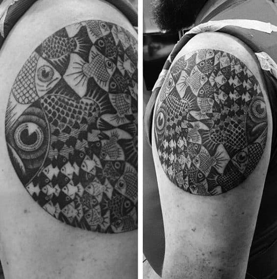 MC Escher-inspired upper arm tattoo featuring a circular tessellation of fish, transitioning from bold central figures to intricate miniatures.